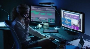 A woman using a computer in an office at night.